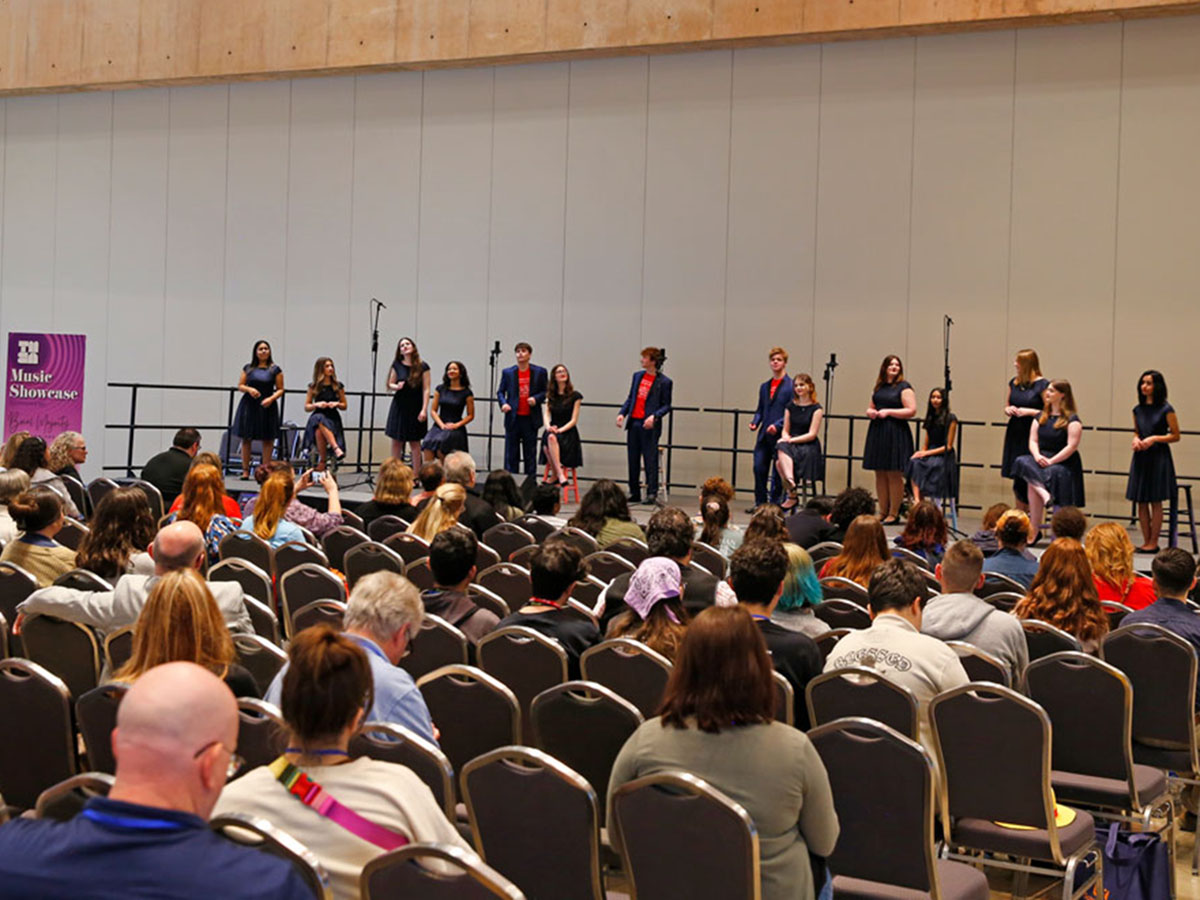 A speaker addressing an attentive audience in a conference hall